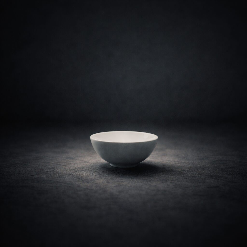 暗い空間に置かれた白い器に光が満ちている